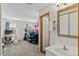 View from bathroom toward office/bedroom with computer desk, chair and storage shelves near windows at 10715 Foxwood Ct, Parker, CO 80138