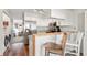 Open kitchen with stainless steel appliances, wood accents, and bar seating seamlessly flows into the living spaces at 10715 Foxwood Ct, Parker, CO 80138