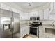 Modern kitchen features stainless steel appliances, granite countertops, and sleek white cabinetry at 10715 Foxwood Ct, Parker, CO 80138