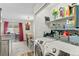 Bright laundry area with modern appliances and storage shelves and with view to the kitchen and dining room at 10715 Foxwood Ct, Parker, CO 80138