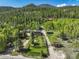 A sweeping aerial view of a home surrounded by dense forest, showing privacy and beautiful green surroundings at 63 Sillasen Ln, Golden, CO 80403