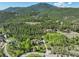 Breathtaking aerial view of a luxurious residence surrounded by towering trees, showcasing the vast landscape and natural beauty at 63 Sillasen Ln, Golden, CO 80403