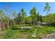 Spacious backyard with trees, green grass, stepping stones and outdoor furniture at 63 Sillasen Ln, Golden, CO 80403