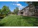 Expansive backyard with lush green grass and mature trees, providing a serene and private outdoor oasis for relaxation at 16301 E Ida Ave, Centennial, CO 80015