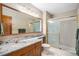 Bright bathroom featuring a marble countertop, wooden cabinetry, and glass shower doors at 16301 E Ida Ave, Centennial, CO 80015