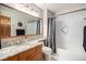 Bathroom featuring a granite countertop, a large mirror, and a shower with decorative tiling at 16301 E Ida Ave, Centennial, CO 80015