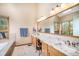 Luxurious bathroom featuring a double vanity, granite countertop, and a large, framed mirror at 16301 E Ida Ave, Centennial, CO 80015