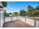 Cozy deck with wooden floors and white railings, offering a view of the surrounding trees at 16301 E Ida Ave, Centennial, CO 80015