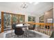 Open dining area with modern chandelier, fireplace view, and access to the balcony at 16301 E Ida Ave, Centennial, CO 80015