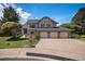 Charming two-story home featuring a manicured lawn and a three-car garage at 16301 E Ida Ave, Centennial, CO 80015