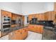 Spacious kitchen with stainless steel appliances, oak cabinets, granite countertops, and center island at 16301 E Ida Ave, Centennial, CO 80015