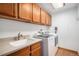 A convenient laundry room with upper cabinets, a sink, and a modern washer and dryer at 16301 E Ida Ave, Centennial, CO 80015