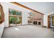 Bright living room features a brick fireplace, large windows, and a sliding door to the backyard deck at 16301 E Ida Ave, Centennial, CO 80015