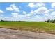 An aerial view of a grass field under a bright blue sky with fluffy white clouds at 1015 S Fulton Ave, Fort Lupton, CO 80621