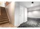 Staircase leads to a carpeted basement area with neutral-toned walls and a white door at 1015 S Fulton Ave, Fort Lupton, CO 80621