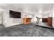 Finished basement features neutral walls, treadmill, and entertainment area with TV at 1015 S Fulton Ave, Fort Lupton, CO 80621