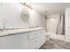 This bathroom has a gray stone countertop, an oval mirror, and a shower-tub with a gray curtain at 1015 S Fulton Ave, Fort Lupton, CO 80621