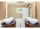 Elegant bathroom featuring dual vessel sinks, large mirror and modern fixtures at 1015 S Fulton Ave, Fort Lupton, CO 80621