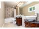 Elegant bathroom featuring dual vessel sinks, large mirror, modern fixtures, and a bathtub shower combo at 1015 S Fulton Ave, Fort Lupton, CO 80621