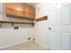 This laundry room includes upper cabinets, a shelf, a door, and tile flooring at 1015 S Fulton Ave, Fort Lupton, CO 80621