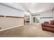 Open and spacious living area with carpet, transitions into an eating nook with views to the yard at 1015 S Fulton Ave, Fort Lupton, CO 80621
