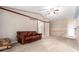 Spacious living room with carpeted floors, a ceiling fan, and a rustic brown leather sofa at 1015 S Fulton Ave, Fort Lupton, CO 80621