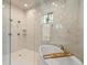 Luxurious bathroom features a soaking tub, separate shower, and sleek marble tile at 2113 Fountain Cir, Erie, CO 80516