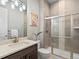 Modern bathroom featuring a shower with glass door, dark wood vanity, and quartz countertop at 2113 Fountain Cir, Erie, CO 80516