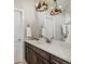 Well-lit bathroom featuring a dark wood vanity, quartz countertop and antler chandeliers at 2113 Fountain Cir, Erie, CO 80516