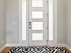 Stylish modern front door with glass panels and black and white patterned rug at 2113 Fountain Cir, Erie, CO 80516