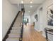 Inviting hallway with staircase features hardwood floors, stylish decor, and natural light throughout at 2113 Fountain Cir, Erie, CO 80516