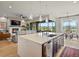 Open-concept kitchen with island, and a view of the living room, dining area and scenic backyard at 2113 Fountain Cir, Erie, CO 80516