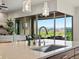 Modern kitchen sink and island with view of an outdoor patio and mountain view at 2113 Fountain Cir, Erie, CO 80516