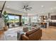 An open living room featuring a modern ceiling fan and a view of the outdoor patio and kitchen at 2113 Fountain Cir, Erie, CO 80516