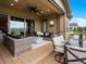 Covered outdoor patio with lounge seating and dining space, overlooking a lush lawn at 2113 Fountain Cir, Erie, CO 80516