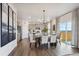 Bright dining area featuring a modern chandelier, wood floors, and access to the backyard at 4206 Sandstone Dr, Mead, CO 80504