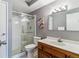 This bathroom features a glass shower, white cabinets and walls, and a brown cabinet with a marble sink at 13626 E Bates Ave # 110, Aurora, CO 80014