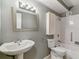 Well-lit bathroom with a pedestal sink, a toilet, and a bathtub with white tile surround at 13626 E Bates Ave # 110, Aurora, CO 80014