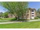 Beautiful exterior view of a well-maintained apartment building surrounded by lush greenery and manicured lawns at 13626 E Bates Ave # 110, Aurora, CO 80014