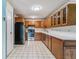 Open kitchen features wooden cabinets and a refrigerator at 13626 E Bates Ave # 110, Aurora, CO 80014