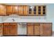 Kitchen featuring wooden cabinetry, stainless steel dishwasher, and ample counter space at 13626 E Bates Ave # 110, Aurora, CO 80014