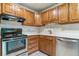 Cozy kitchen with wooden cabinetry, tiled backsplash, and stainless steel appliances at 13626 E Bates Ave # 110, Aurora, CO 80014