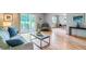 Open living room area featuring wood floors, a gray sofa, and a view into the dining space at 13626 E Bates Ave # 110, Aurora, CO 80014