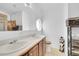 Bright bathroom featuring double sinks, wood cabinets, and a unique window at 6631 E 78Th Avenue Ave, Commerce City, CO 80022