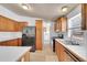 Updated kitchen with stainless steel appliances, wood cabinets, and tile flooring at 6631 E 78Th Avenue Ave, Commerce City, CO 80022