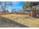 Backyard featuring brown grass, some trees, and a wooden fence at 13577 W Alaska Dr, Lakewood, CO 80228