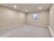This basement is carpeted with neutral walls, recessed lights and a view of a window at 13577 W Alaska Dr, Lakewood, CO 80228