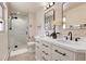 Modern bathroom with double vanity, quartz counters, and frameless glass shower at 13577 W Alaska Dr, Lakewood, CO 80228