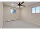 This bedroom features neutral walls, carpet, a ceiling fan and natural light from two windows at 13577 W Alaska Dr, Lakewood, CO 80228