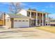 Beautifully landscaped home featuring a brick exterior, attached garage and charming architectural details at 13577 W Alaska Dr, Lakewood, CO 80228